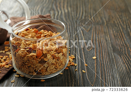 Glass jar with tasty granola on wooden background Glass jar with tasty granola on wooden background 72333626