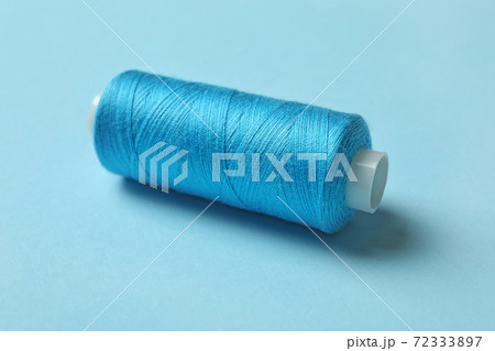 Blue sewing thread on blue background, close up 72333897