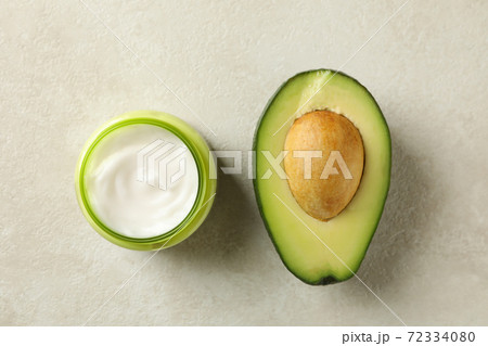 Jar of cosmetic cream and avocado, top view 72334080