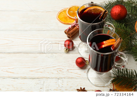 Cups of mulled wine and Christmas accessories on wooden background 72334164