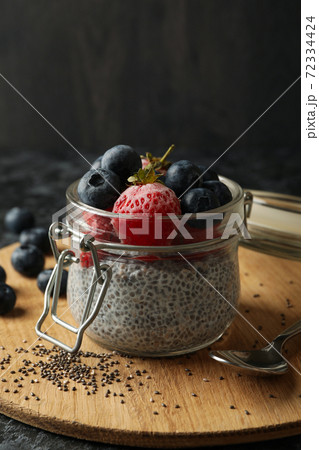 Board with jar of delicious chia pudding on black smokey table Board with jar of delicious chia pudding on black smokey table 72334424