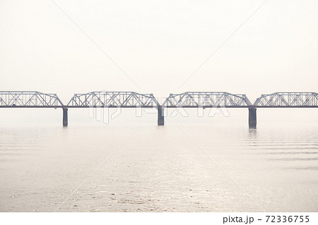 railroad truss bridge over a wide river in fog railroad truss bridge over a wide river in fog 72336755