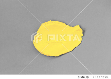 Smear of yellow clay on gray background. 72337650