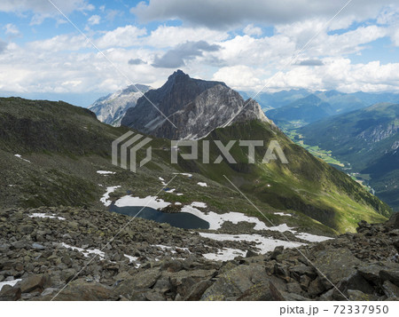 view on Alfairsee blue mountain lake and Innsbrucker Hutte mountain hut with moutain peak panorama at Stubai hiking trail, Stubai Hohenweg, Tirol Alps, Austria. Summer blue sky, white clouds view on Alfairsee blue mountain lake and Innsbrucker Hutte mountain hut with moutain peak panorama at Stubai hiking trail, Stubai Hohenweg, Tirol Alps, Austria. Summer blue sky, white clouds 72337950