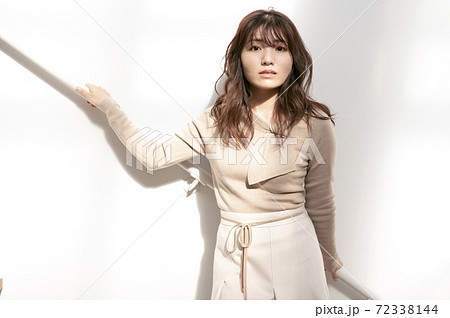 階段の手すりに寄りかかる若い女性の写真素材