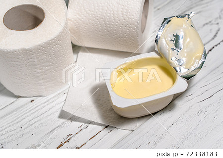 Pack of yogurt with tiolet paper on white wooden desk. 72338183