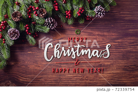 Christmas branches decoration concept with berries, stars and pine cones on old wooden background Christmas branches decoration concept with berries, stars and pine cones on old wooden background 72339754