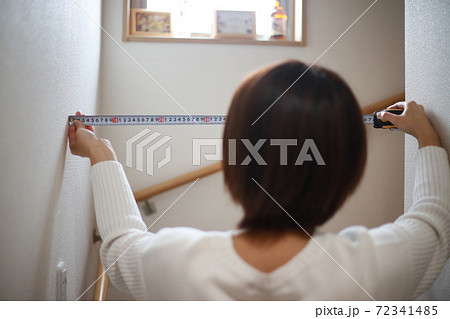階段の幅を測る女性 72341485