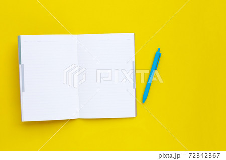 Notebook with pen on yellow background. 72342367