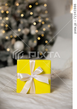 . Yellow gift with white ribbon 72343986