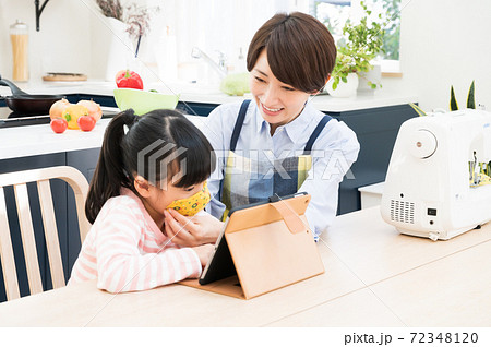 手作りマスクを子供に合わせる母親 72348120