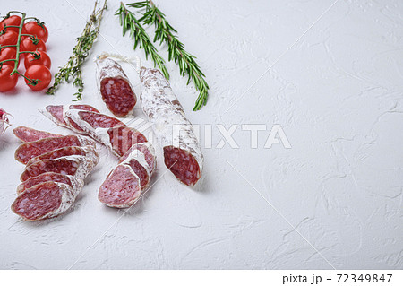 Dry cured fuet salami sausage slices with herbs on 72349847