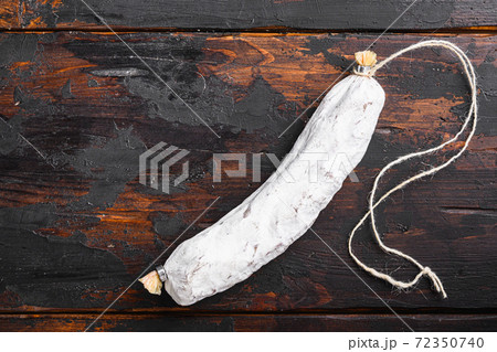 Dry cured salchichon spanish wurst on dark wood Dry cured salchichon spanish wurst on dark wood 72350740