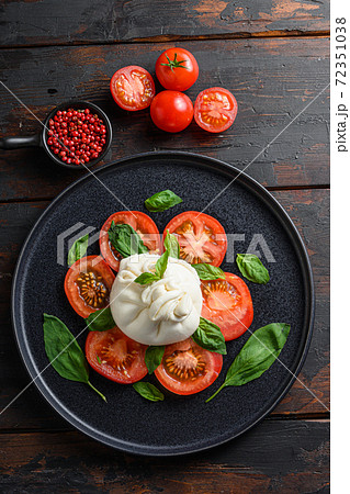Handmade burrata cheese served with fresh tomatoes Handmade burrata cheese served with fresh tomatoes 72351038