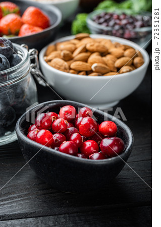 Ripe cranberry in black bowl, on black wooden background Ripe cranberry in black bowl, on black wooden background 72351281