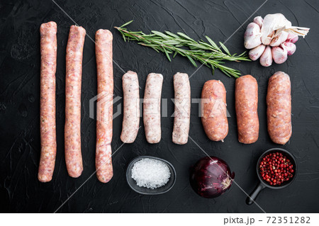 Raw sausages, top view, on black background Raw sausages, top view, on black background 72351282
