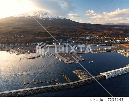 初冬の北海道森町砂原港を出漁する漁船の朝の風景を空撮 72351434