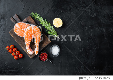 Slice of red fish salmon with herbs, over black background, flat view with space for text Slice of red fish salmon with herbs, over black background, flat view with space for text 72351625