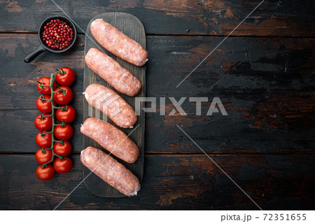 Raw pork sausages, top view with space for text, on old dark wooden background 72351655
