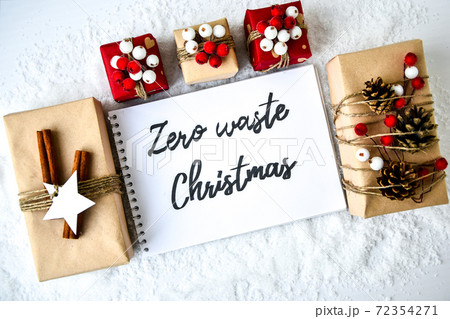 Zero waste Christmas text with presents with decorations on white snow background. Copy space. Eco friendly packed gift with tags from craft cardboard 72354271