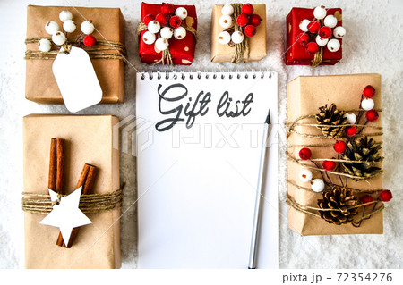 Notebook with GIFT LIST text Zero waste Christmas text with presents with decorations on white snow background. Copy space. Eco friendly gift craft cardboard Notebook with GIFT LIST text Zero waste Christmas text with presents with decorations on white snow background. Copy space. Eco friendly gift craft cardboard 72354276