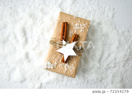 Zero waste Christmas presents with decorations on white snow background. Copy space. Eco friendly packed gift with tags from craft cardboard Zero waste Christmas presents with decorations on white snow background. Copy space. Eco friendly packed gift with tags from craft cardboard 72354279