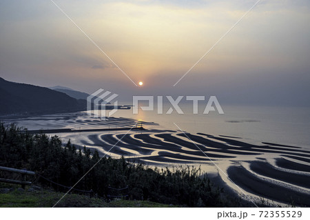有明海に沈む夕日に照らされる御輿海岸の風景 有明海に沈む夕日に照らされる御輿海岸の風景 72355529