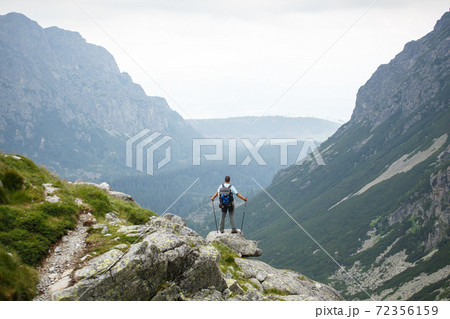 Hiker at the top of a rock with backpack Hiker at the top of a rock with backpack 72356159