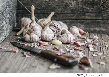 Garlic banner. Garlic bulbs and old knife on wooden rustic table. Blurred back and front. Garlic banner. Garlic bulbs and old knife on wooden rustic table. Blurred back and front. 72357407