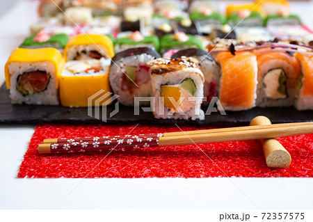 Wooden chopsticks on a red mat in the foreground. Wooden chopsticks on a red mat in the foreground. 72357575