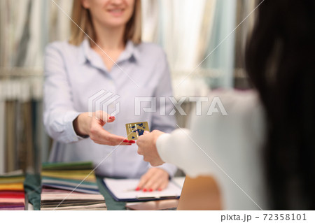 Customer handing credit bank card to sellers hand closeup 72358101