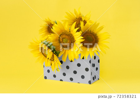 Color of the year 2021. Illuminating and Ultimate Gray. Yellow sunflowers in Gray shopping bag on yellow background, web banner Color of the 2021 year 72358321