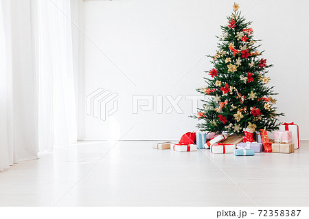 decorated Christmas tree with New Year's gifts in a room with a window 72358387