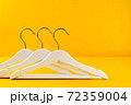 White hangers on a yellow background. Sales clothes concept. 72359004