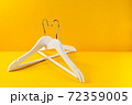 White hangers on a yellow background. Sales clothes concept. 72359005