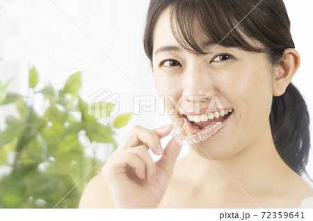 片手でマウスピースを持つ女性 72359641