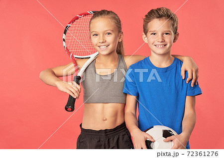 Adorable sporty girl and boy standing against red background 72361276