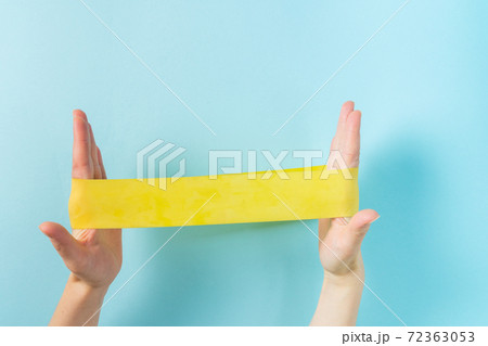Home training concept - hands holding elastic bands on blue background 72363053
