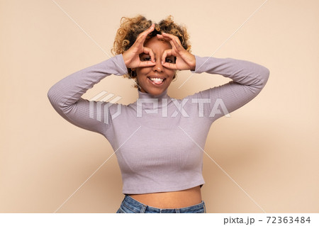 African woman making glasses shape, looking through binoculars gesture African woman making glasses shape, looking through binoculars gesture 72363484