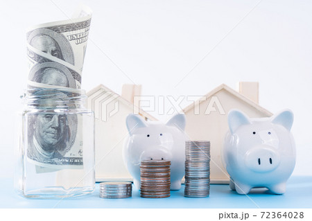 Piggy bank with stack coins and money paper inside jar and wooden house isolated grey background. Property investment and house mortgage financial concept. 72364028