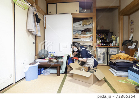 散らかった部屋を片付ける女性作業員 72365354