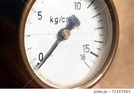 Close-up of an old industrial pressure gauge display with worn protective glass. Macro 72367005