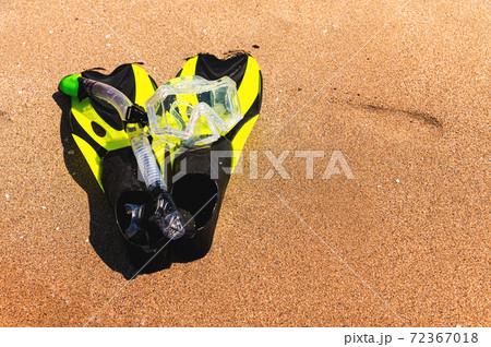 Snorkeling equipment set snorkel mask fins lie on golden sand by the seashore 72367018