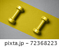 Yellow color dumbbells on the gray mat 72368223