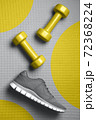 Yellow color dumbbells and gray color sneakers on the mat 72368224
