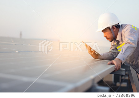 Engineer solar photovoltaic panels station checks with tablet computer. Energy technology concept 72368596