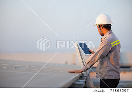 Engineer solar photovoltaic panels station checks with tablet computer. Energy technology concept 72368597