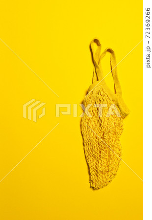 Empty bright yellow mesh bag on yellow paper Empty bright yellow mesh bag on yellow paper 72369266