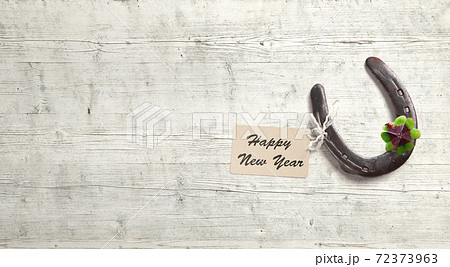Horseshoe with lucky clover on a wooden background Horseshoe with lucky clover on a wooden background 72373963