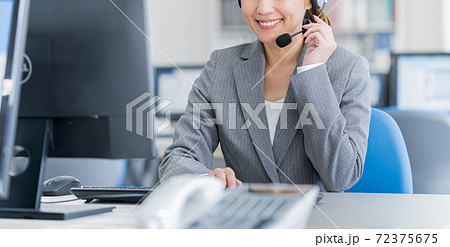 コールセンターで働く若いビジネスウーマン 72375675